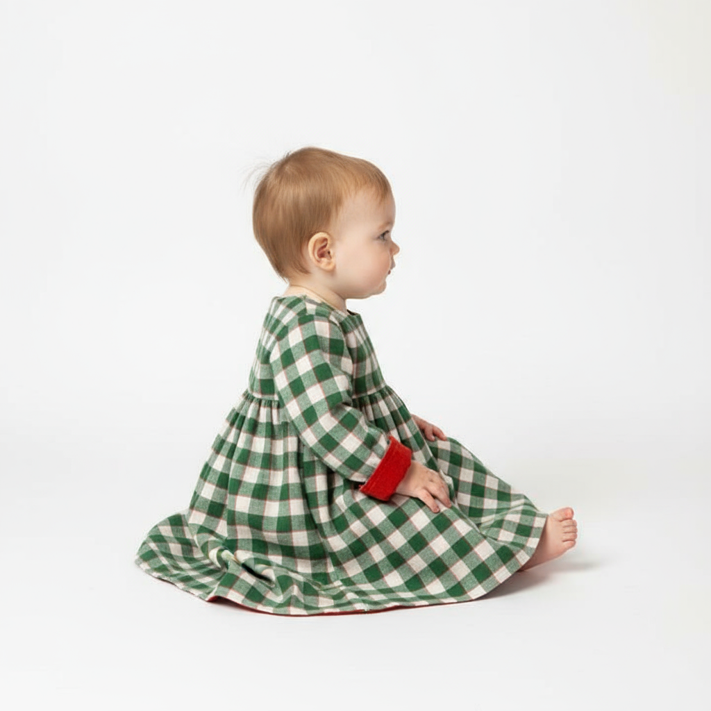Studio side profile of baby in plaid dress