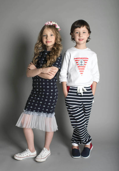 Two kids in stylish navy and white nautical outfits, from Ivorynn kids’ fashion collection