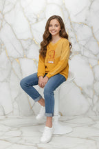 طفلة جالسة ترتدي السويتر برقم 1