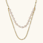Layered gold chain necklace with organic baroque freshwater pearls and adjustable length on cream background
