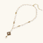 Y-shaped necklace with freshwater pearls, gold filigree stations, and ornate diamond-shaped centerpiece with pearl drop