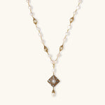 Y-shaped necklace with freshwater pearls, gold filigree stations, and ornate diamond-shaped centerpiece with pearl drop