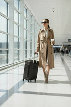 امرأة تمشي في المطار مع الحقيبة السوداء