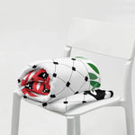 Floral country flag throw blanket in ivory with black grid, red and green accents on a white chair