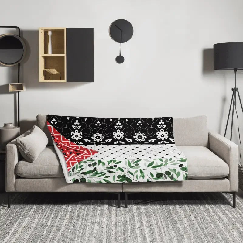 Floral country flag throw blanket with black, red, and green patterns on a modern sofa in a contemporary living room