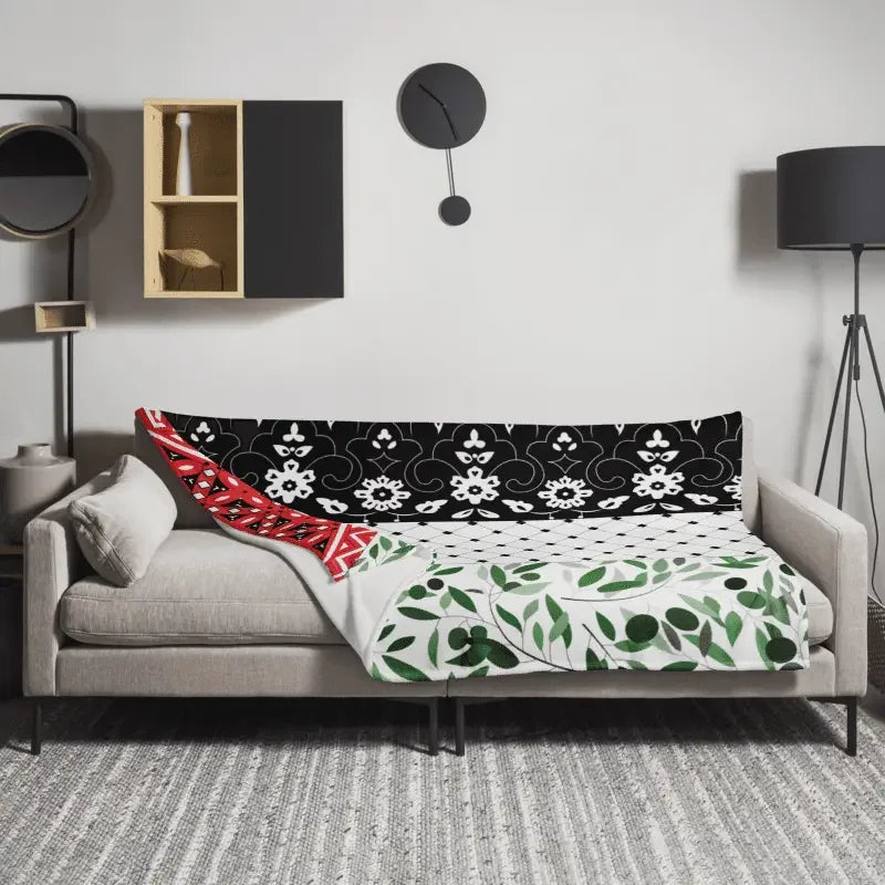 Floral patterned throw blanket with black, white, red, and green details on a modern sofa