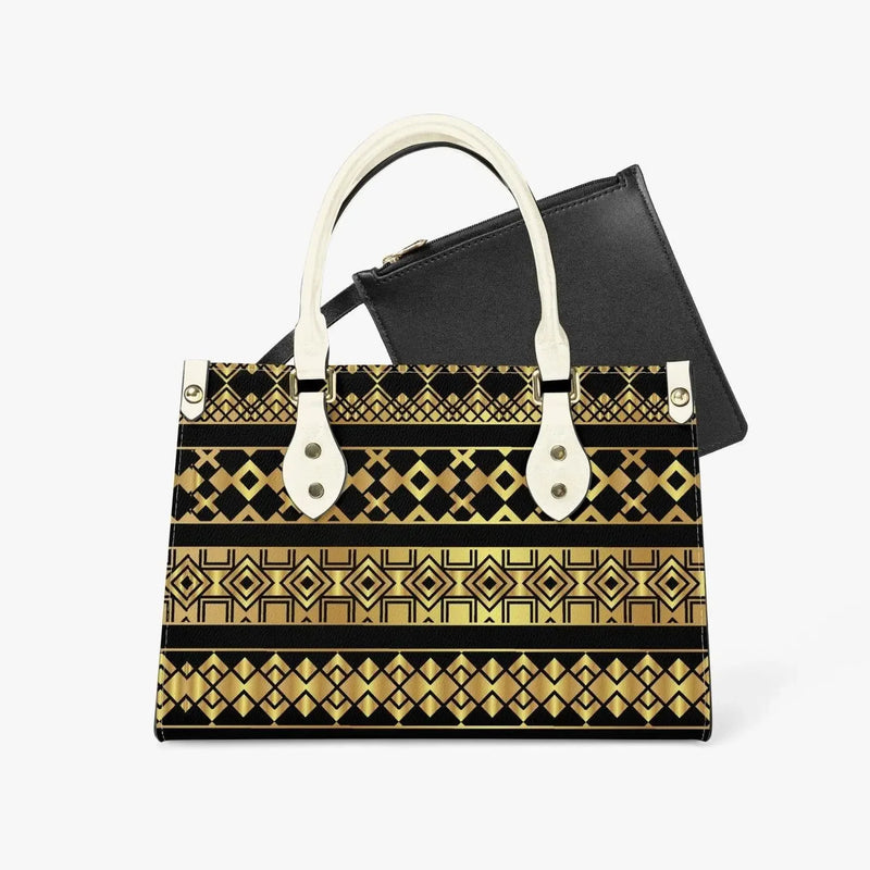 Geometric gold and black tote bag with ivory handles and black inner pouch on white background