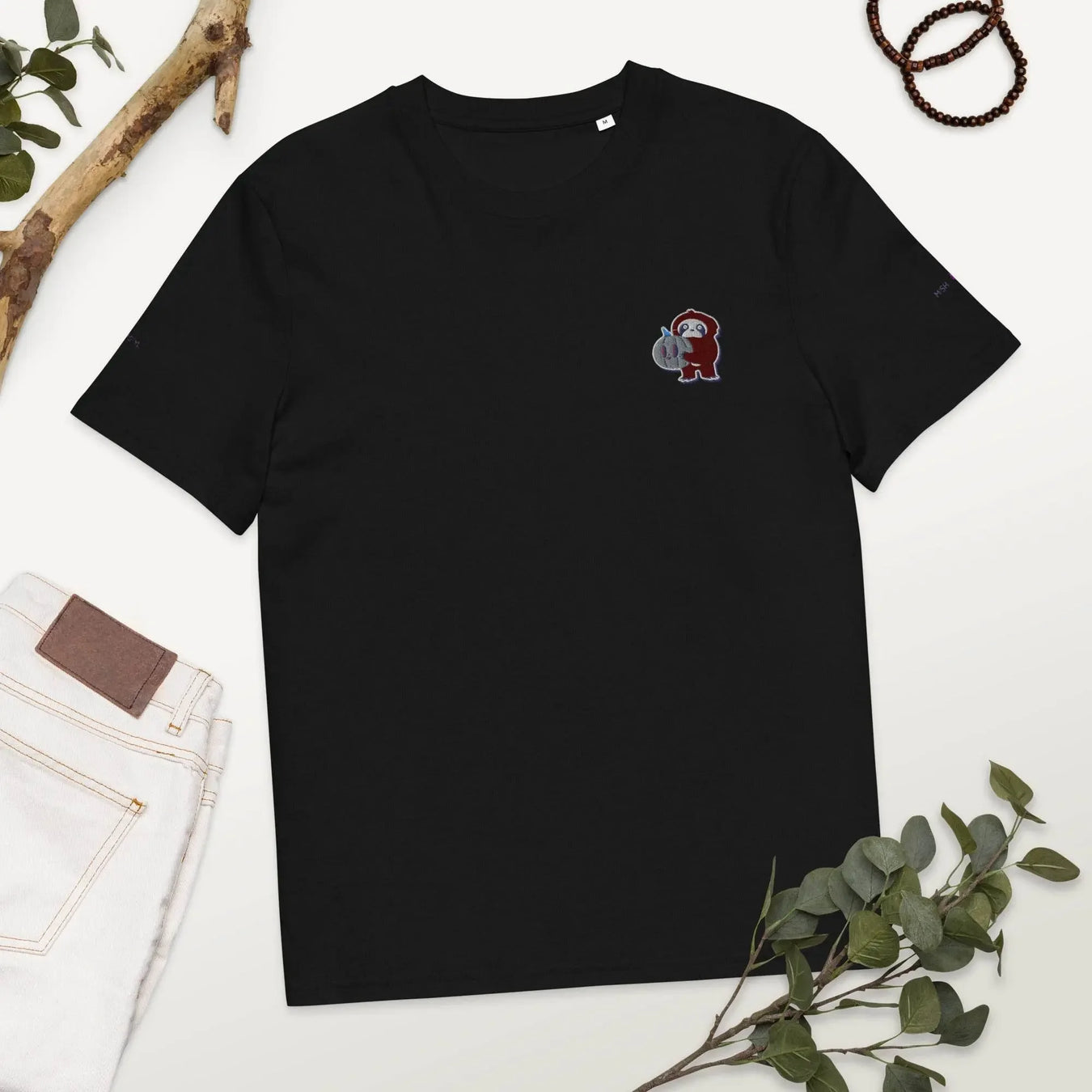 Black organic cotton t-shirt with embroidered cartoon monkey, styled with jeans and greenery, Ivorynn fashion