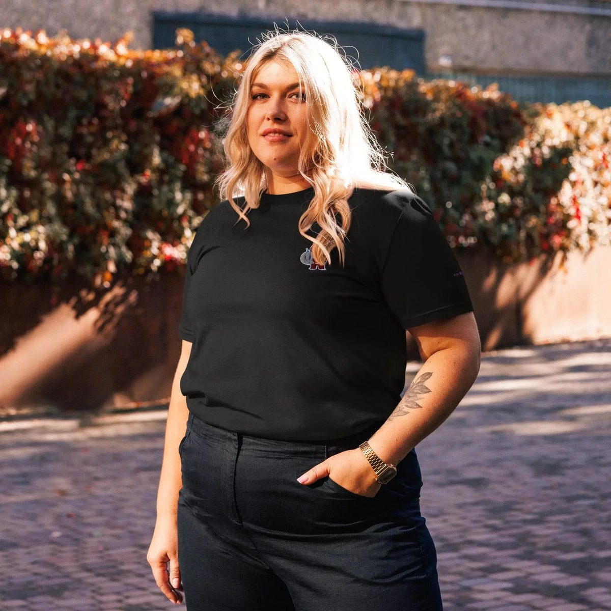 Woman outdoors wearing IVORYNN embroidered little monkey organic cotton t-shirt in black