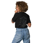 Woman wearing black graphic t-shirt with coffee-themed quote and light blue jeans