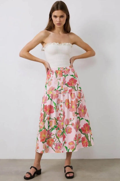 Woman wearing floral elastic waist ruffle slit hem skirt in ivory from Ivorynn fashion collection