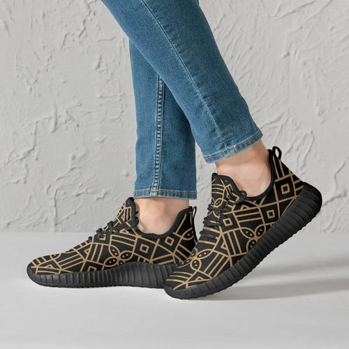 Men's black and gold geometric knit mesh sneakers from Ivorynn, worn with blue jeans.