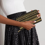 Woman holding black wallet with gold Palestinian geometric patterns, modern fashion accessory