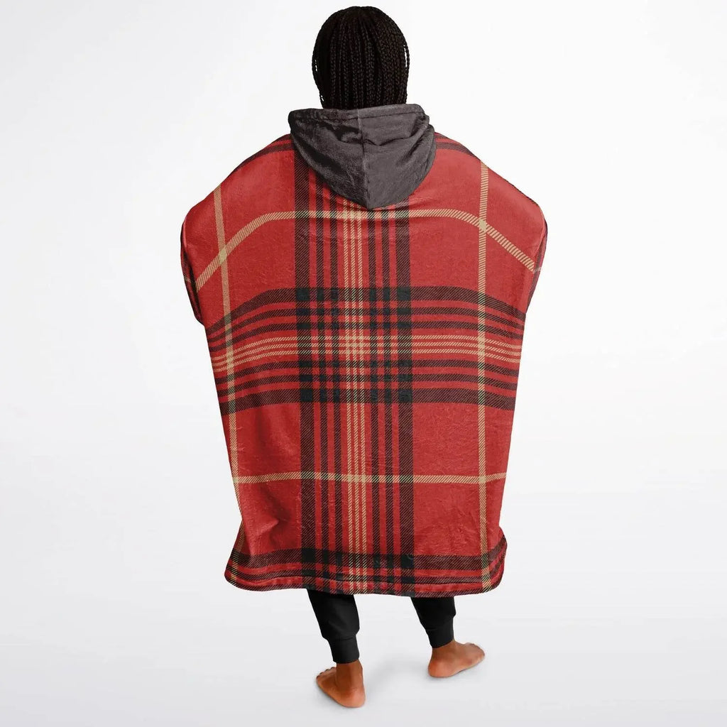 Woman wearing oversized red plaid cozy hoodie with gray hood, standing barefoot on white background