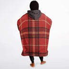 Woman wearing oversized red plaid cozy hoodie with gray hood, standing barefoot on white background