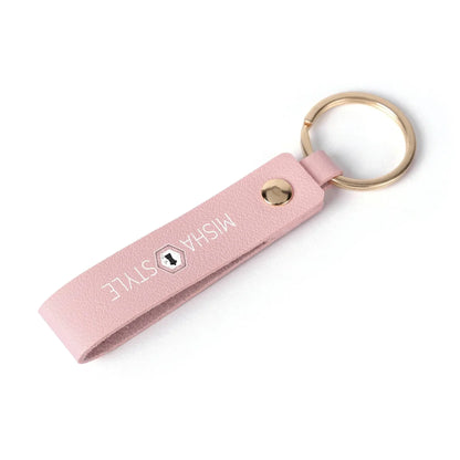 Pink leather keychain with gold ring and MISHA STYLE logo on white background