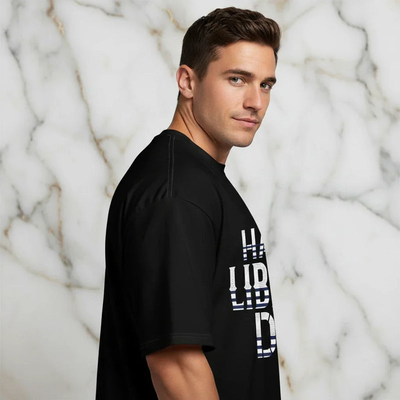 Athletic man in black graphic t-shirt posing against marble background, Ivorynn men’s fashion