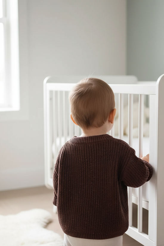 Baby back view near crib
