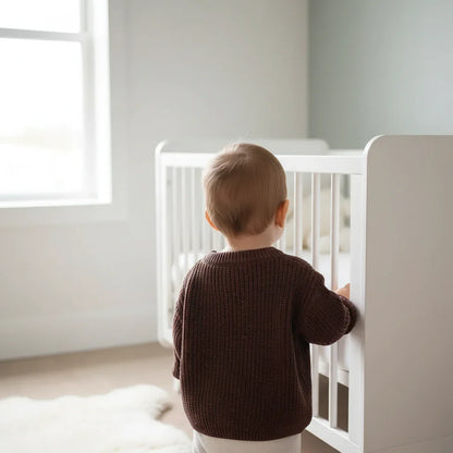 Baby back view near crib