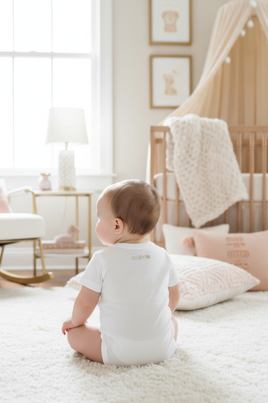 Baby girl wearing IVORYNN onesie - back view