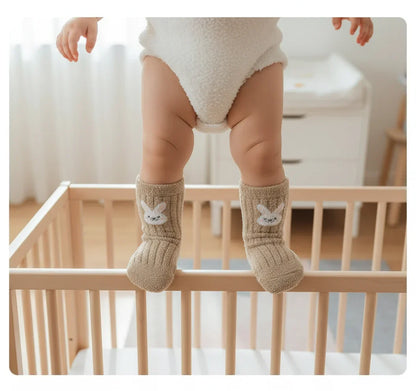 Baby wearing beige fuzzy socks - overhead view