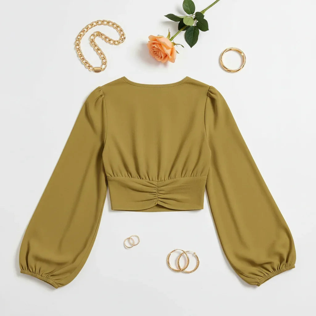 Back view on white surface with gold jewelry and peach rose