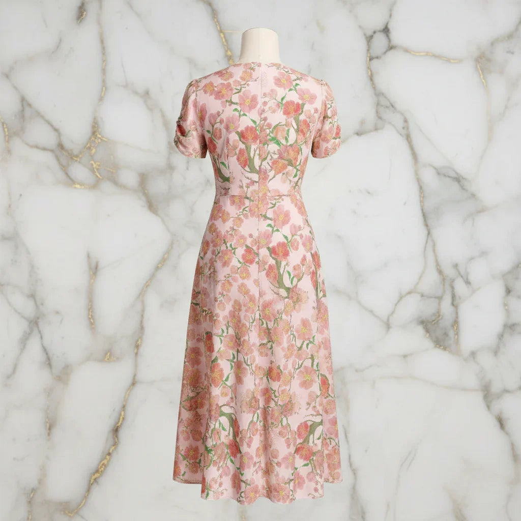 Back view of a pink floral print midi dress on mannequin, elegant women's fashion at Ivorynn