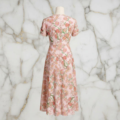 Back view of a pink floral print midi dress on mannequin, elegant women's fashion at Ivorynn