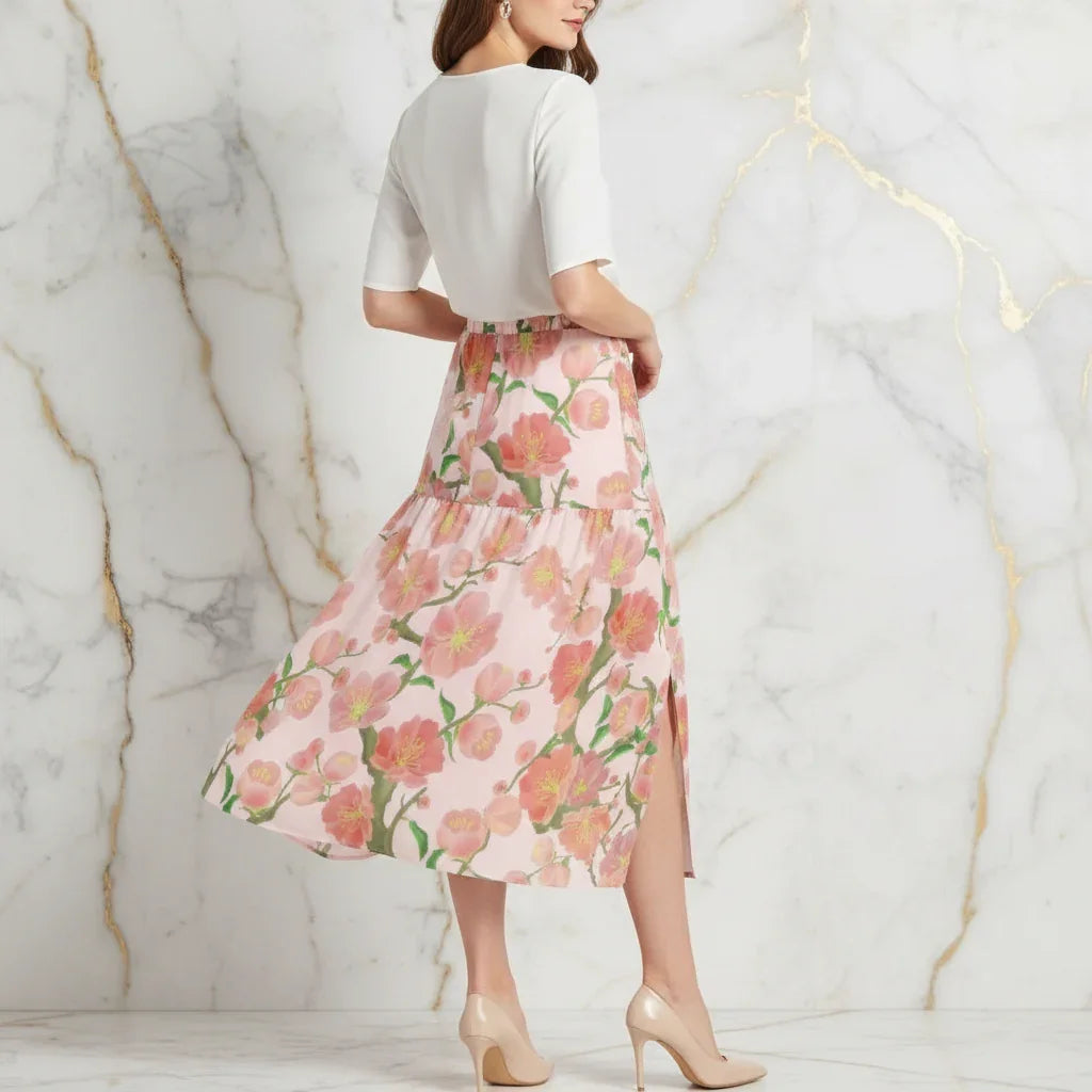 Woman in white top and floral pink maxi skirt with slit, wearing nude heels, Ivorynn fashion