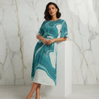 Woman in teal marble print dress leaning on pedestal, modern marble wall, Ivorynn fashion