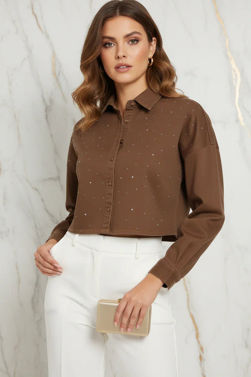 Close-up detail of brown denim shirt rhinestones on marble background