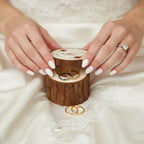 Bride with elegant nails opening rustic ring box on wedding dress, gold and silver rings inside
