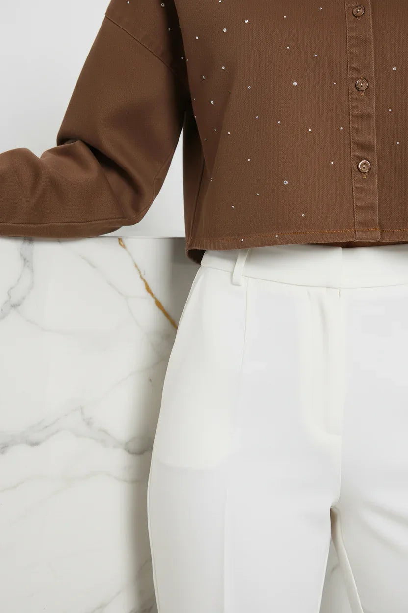 Close-up of cropped hemline meeting white pants