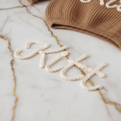 Close-up of "Kitt" embroidered text