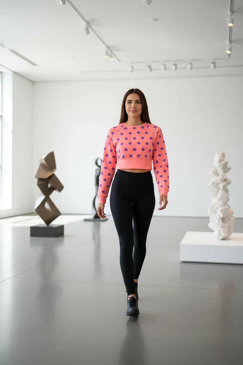 Woman in pink polka dot crop top and black leggings walking in modern art gallery, Ivorynn fashion