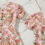 Pink floral short-sleeve dress with buttons on marble surface, stylish women's fashion at Ivorynn