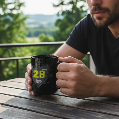 Man holding a black dubstep mug with yellow print on an outdoor patio table at Ivorynn.