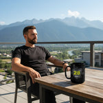 Man relaxing on balcony with black Dubstep 28 mug, scenic mountains in background, Ivorynn lifestyle