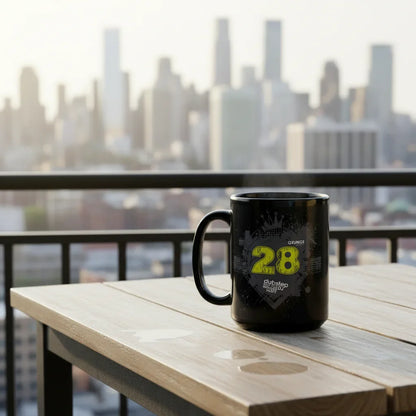 Black dubstep mug with yellow '28' design on outdoor table, city skyline background, Ivorynn