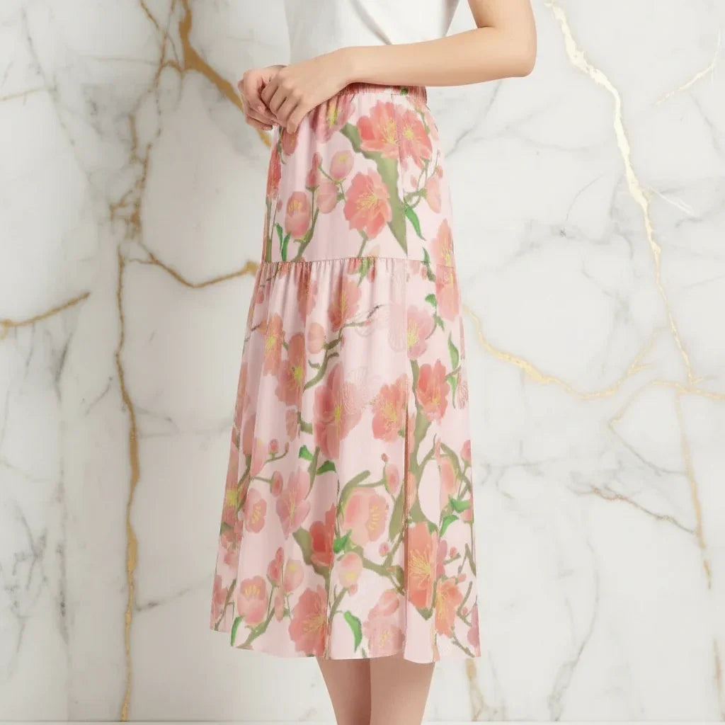 Woman in elegant floral midi skirt by Ivorynn, side pose, marble background.