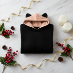Folded hoodie with red berries and gold accents