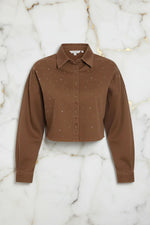 Front view of brown denim shirt on marble background