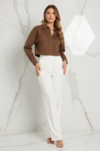 Front view of brown denim shirt with white pants on marble background