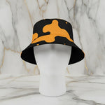 Black and yellow camo bucket hat on a mannequin, luxury accessory at Ivorynn