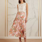 Woman in sleeveless white top and floral pink midi skirt with front slit, Ivorynn fashion