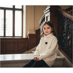 Girl in cream fleece sweater near staircase