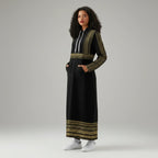 Woman in a black and gold embroidered hoodie dress, white sneakers, studio backdrop, Ivorynn fashion