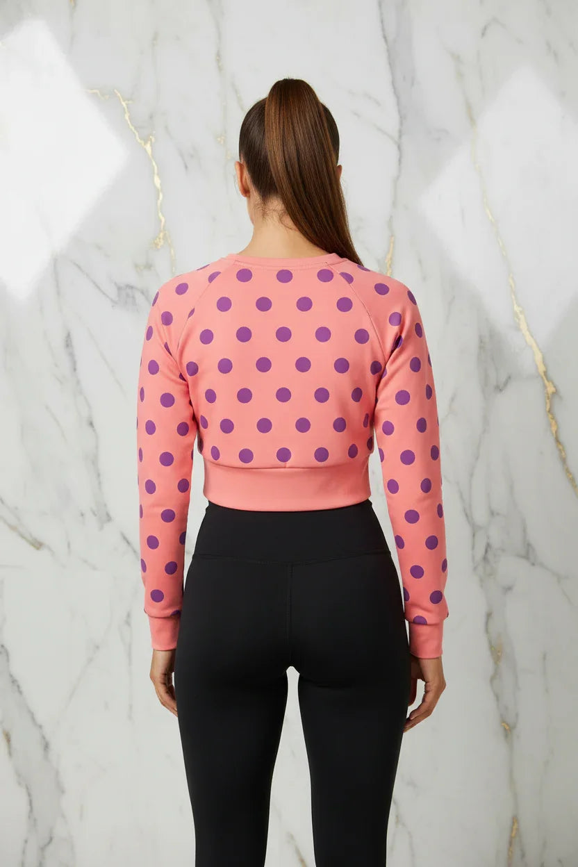 Woman wearing pink polka dot cropped sweatshirt and black leggings, Ivorynn fashion