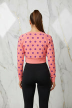 Woman wearing pink polka dot cropped sweatshirt and black leggings, Ivorynn fashion