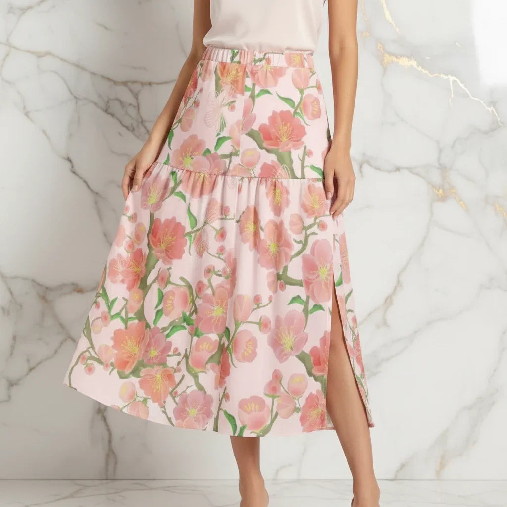 Woman modeling a pink floral midi skirt with side slit, stylish women's fashion at Ivorynn